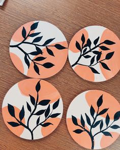 four coasters with painted leaves on them