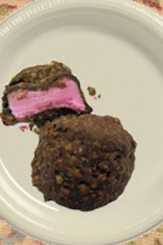 two pieces of chocolate and pink ice cream on a white plate