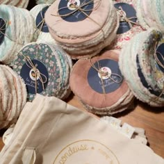 several round pieces of fabric sitting on top of a wooden table next to a bag