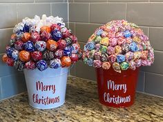 two buckets filled with christmas candies sitting on top of a counter next to each other