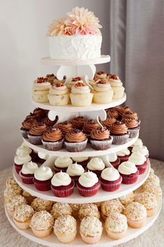 a three tiered cake with cupcakes on it