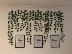 the wall is covered with green leaves and framed pictures