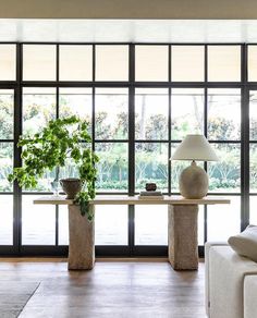 a living room filled with furniture and large windows