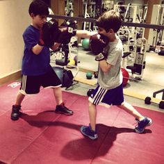 two young boys practicing boxing in the gym