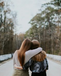 two women hugging each other on the road