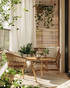 a wooden table sitting on top of a hard wood floor next to a white curtain