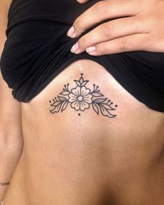 a woman's stomach with a flower tattoo on her belly and the bottom part of her lower back