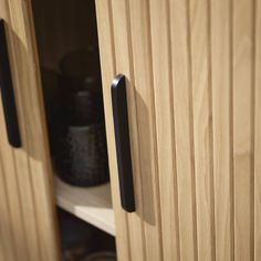 a wooden cabinet with black handles and knobs