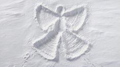 an angel made out of snow on the ground