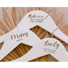 three personalized wedding hangers with names and date printed on them, sitting next to each other