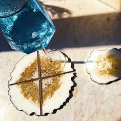 two plates with food on them next to a blue water bottle and spoons sitting on a table