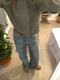 a person standing in front of a mirror with their hands on their hips and wearing jeans