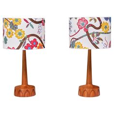 two lamps with floral designs on them sitting side by side in front of a white background