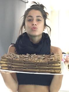 a woman holding a cake in front of her face