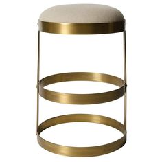 a gold stool with a white cushion on the top and two metal rings around it