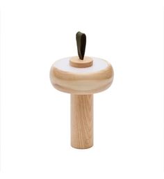 a small wooden object with a black handle