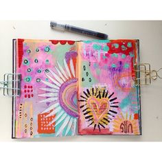 an art journal with a pen on top of it