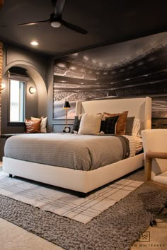 a bedroom with a large bed and a ceiling fan in the corner next to it