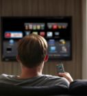 a man sitting on a couch watching tv