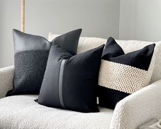 three black and white pillows sitting on top of a couch