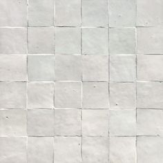 a white tile wall with small squares on it