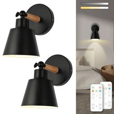 two black wall lights with remote controls next to each other in front of a bed