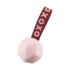 a pink object with the word oxo on it's side hanging from a string