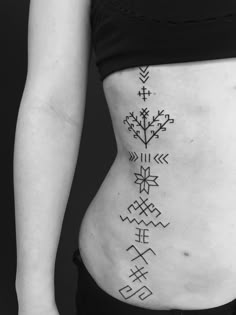 a woman's stomach with an arrow tattoo on her side and arrows in the middle