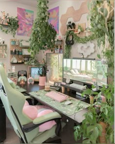 a desk with two computer monitors on top of it next to a potted plant