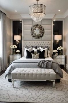 a large bed sitting in a bedroom under a chandelier