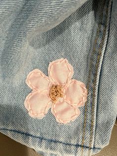 a pink flower is on the back of a pair of jeans