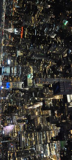 an aerial view of the city lights at night from high up in the skyscrapers