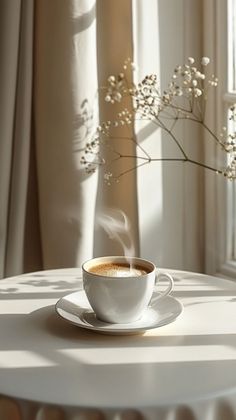 a cup of coffee sitting on top of a white table