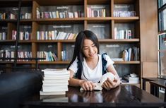 a woman sitting at a table with books in front of her