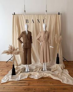 two mannequins dressed in brown and tan clothing on display next to each other