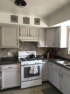 a white stove top oven sitting inside of a kitchen