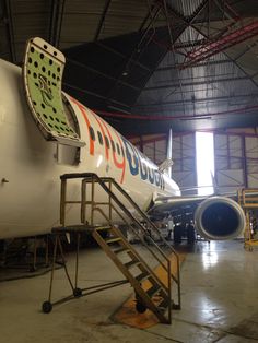 an airplane parked in a hanger with stairs leading up to the plane's door