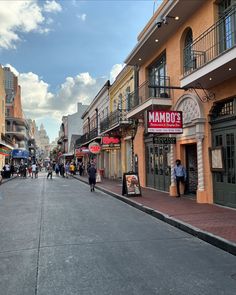 people are walking down the street in front of shops