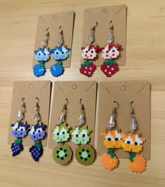 six pairs of earrings made to look like video games characters are shown in different colors and shapes