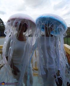 two women dressed in white and blue with jelly hats on their heads, standing next to each other