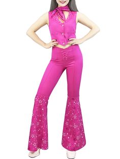 a woman in pink is posing with her hands on her hips and wearing bell bottoms