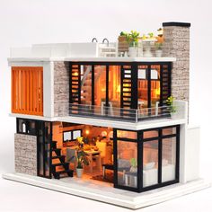 a doll house with two floors and windows on the second floor is lit up at night