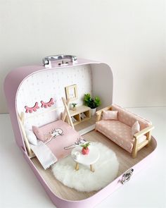 a doll house with furniture and accessories in the shape of a suitcase on a table