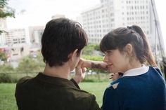 two people standing next to each other in the grass