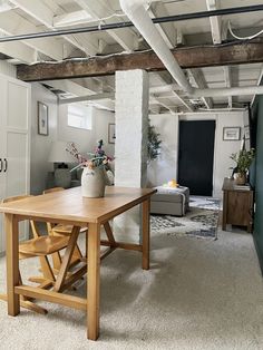 a table and chairs in a room with exposed ceiling beams on either side of it