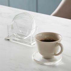 a cup of coffee sitting on top of a white table