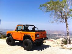 an orange truck parked on top of a hill