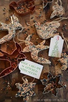 some christmas cookies are sitting on a table with tags attached to the cookie cutters