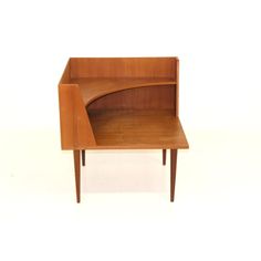 a small wooden desk with a curved shelf