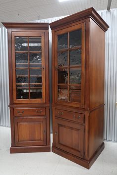 two wooden china cabinets sitting next to each other